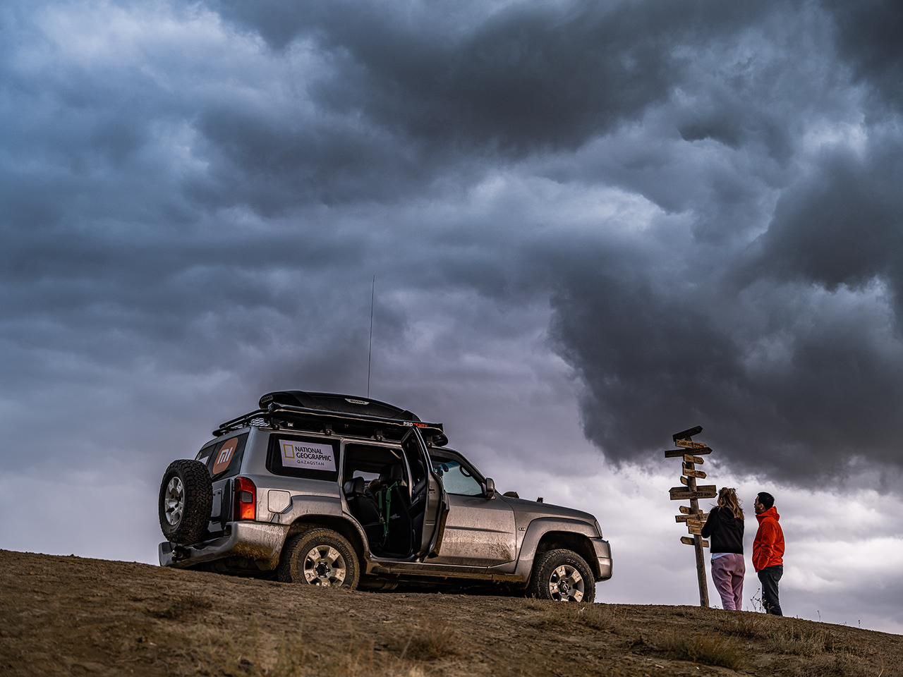 An image of our guests standing next to a jeep admiring the view